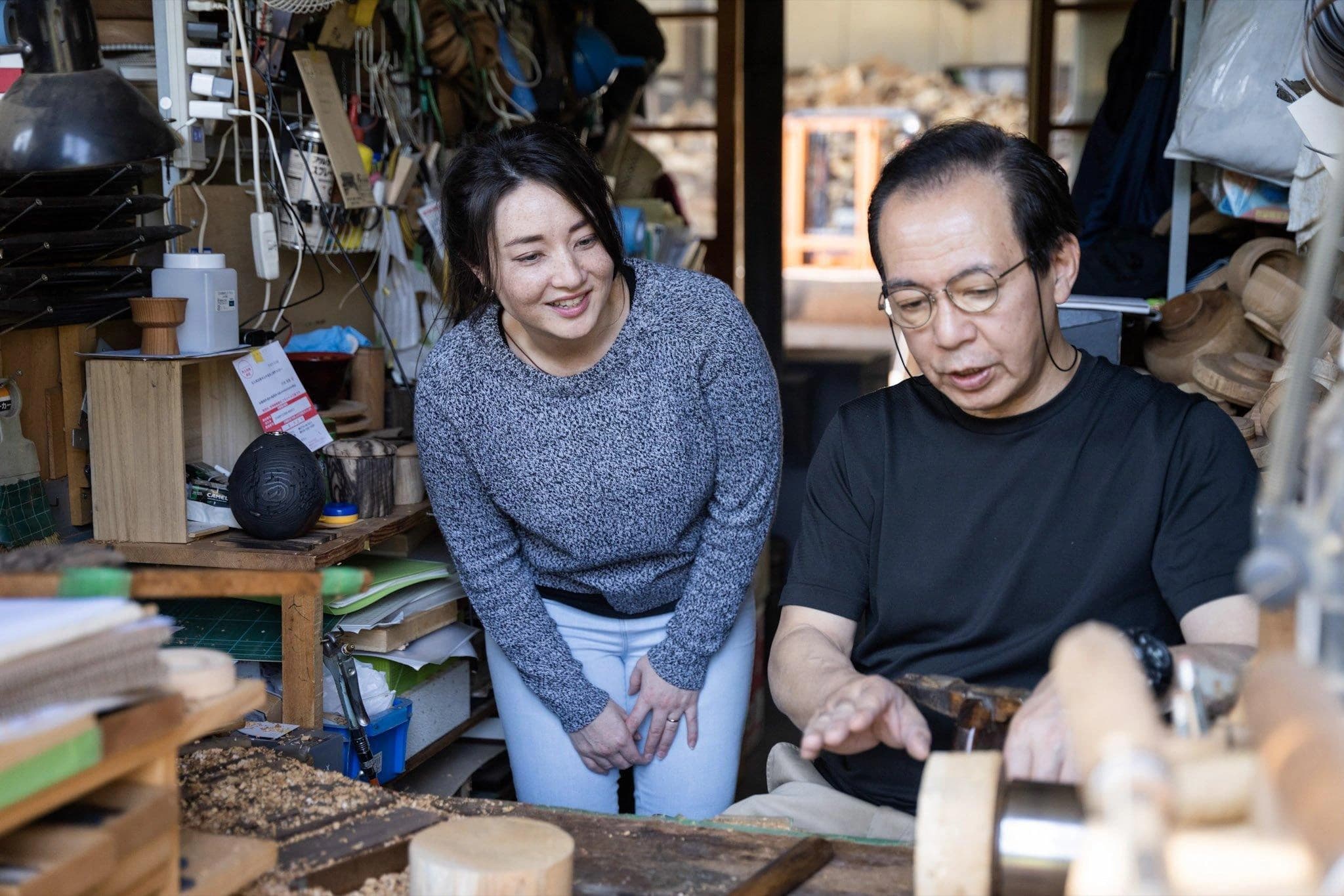 A YMI Experience team member observing a Japanese artisan at work in his workshop.